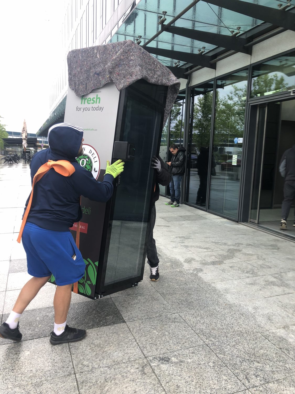 A fridge being carried into a building